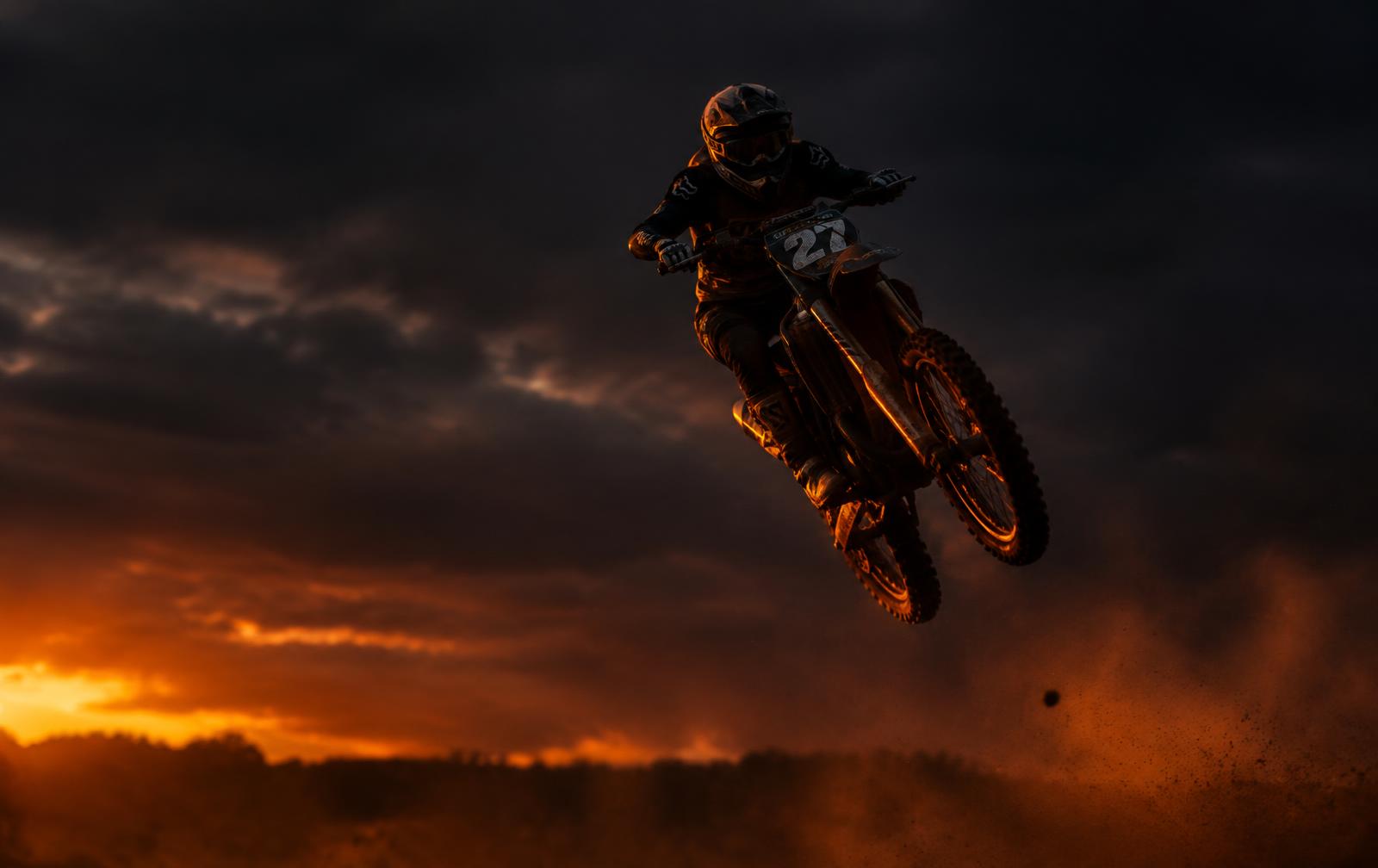 Motocross rider in mid-air at sunset